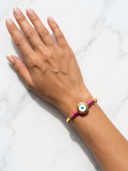 Χρυσό βραχιόλι bangle με φούξια μακραμέ πλέξη και μεγάλο μάτι